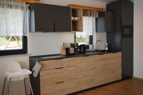 a kitchen with black cabinets and a counter top at Rodinný apartmán Čistá in Cerny Dul
