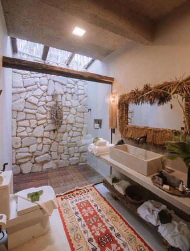 a bathroom with a stone wall and a sink at Zai Patacho in Pôrto de Pedras