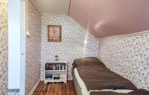 a small bedroom with pink wallpaper and a bed at Nice Apartment In Landeryd With Wifi in Långaryd