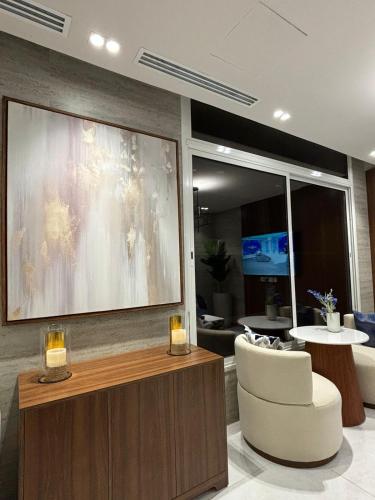 a living room with a large painting on the wall at رنز بالاس للشقق الفندقية in Dammam
