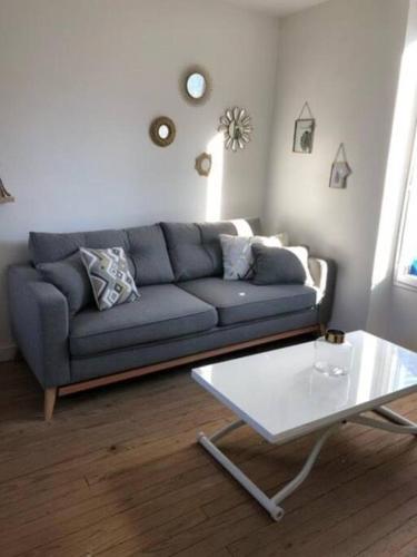 un salon avec un canapé bleu et une table dans l'établissement Authentique House à côté de Disneyland Paris, à Montévrain