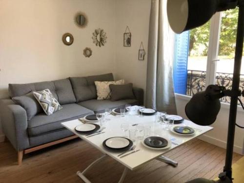 un salon avec une table et un canapé dans l'établissement Authentique House à côté de Disneyland Paris, à Montévrain