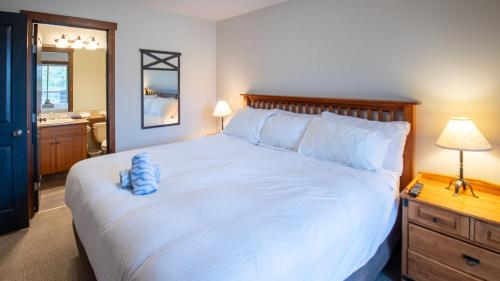 a bedroom with a large bed with a blue stuffed animal on it at Snow Creek Lodge by Fernie Lodging Co in Fernie