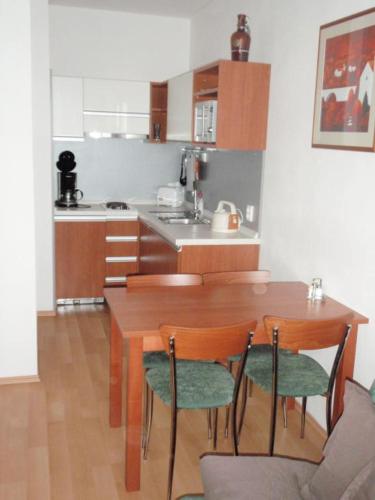 una cucina con tavolo e sedie in legno e tavolo e una cucina di Apartmán Ramzová B14 a Ramzová