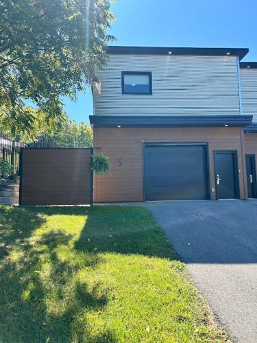 a house with two garage doors and a driveway at Cribs on the Hill in Picton