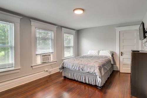 a bedroom with a bed and two windows at Madison Home Walk to Main Street! in Madison