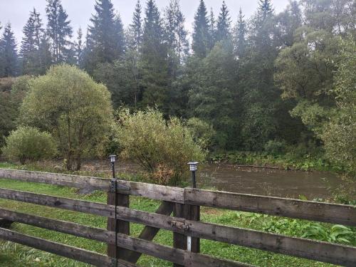 a wooden fence with trees in the background at Vila Irina in Poiana Stampei