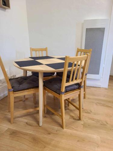 - une table à manger avec 3 chaises, une table, une table et des chaises dans l'établissement Le Valentin Charmant 2 pièces, à Belfort