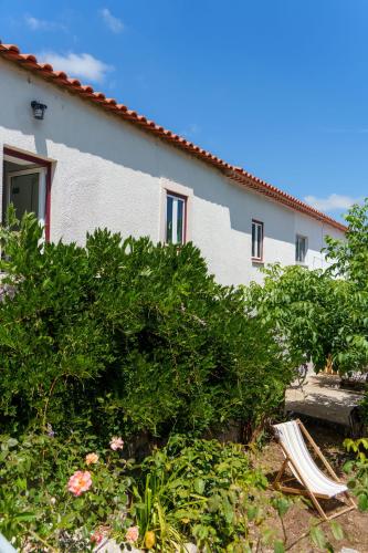 a house with a bunch of bushes and a chair at Casa Alba, desde 1926 in Alvados