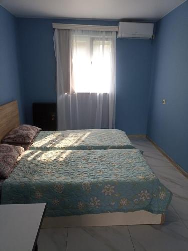a bedroom with two beds in front of a window at 1 room studio guesthouse in Batumi in P'eria