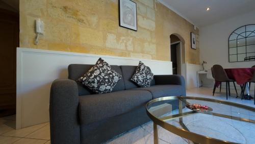un salon avec un canapé et une table en verre dans l'établissement Escapade aux Chartrons, à Bordeaux