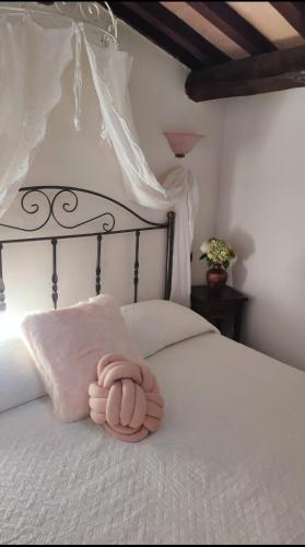 a pink towel laying on a white bed at La Casa Di Miri in Foligno
