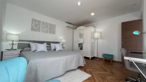 una camera da letto con un letto bianco, una scrivania e una scrivania di Piso con gran terraza en malaga arenas ad Arenas