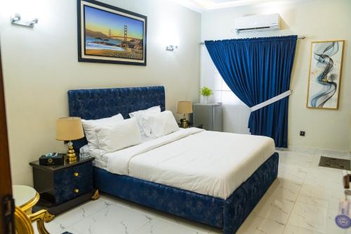 a bedroom with a blue bed and a blue curtain at Diplomat Fort Boutique Hotel in Karachi
