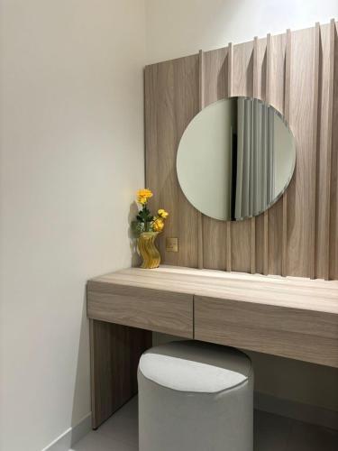 a bathroom with a mirror on a wooden wall at رنز بالاس للشقق الفندقية in Dammam