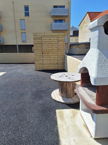 un banc et une table dans un parking dans l'établissement green, à Fort-Mahon-Plage