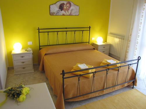 een slaapkamer met een bed met 2 nachtkastjes en 2 lampen bij Corte Dante in Taglio di Po