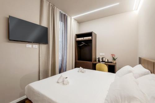 a hotel room with two beds and a flat screen tv at D & D Rooms in La Spezia