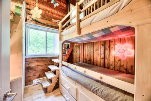 a bedroom in a log cabin with two bunk beds at Domaine Chalets des pins in Rawdon