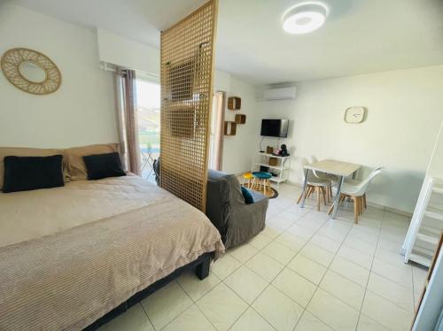 une chambre avec un lit, une table et des chaises dans l'établissement Studio climatisé - Port Fréjus, plage à 250m, à Fréjus