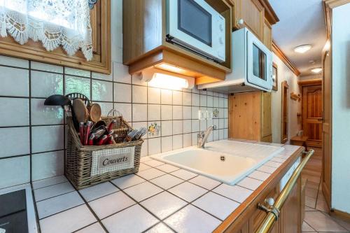 une cuisine avec un évier et un micro-ondes dans l'établissement Résidence Alpages D - ALPAGES D1 MAE-3911, à Les Allues