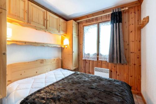 une chambre avec un lit et une fenêtre dans l'établissement Résidence Alpages D - ALPAGES D1 MAE-3911, à Les Allues