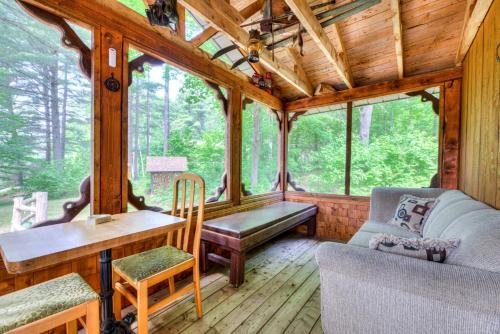 a living room of a wooden cabin with a desk and a couch at Domaine Chalets des pins in Rawdon