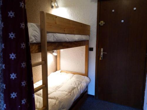 Ce lit superposé se trouve dans un dortoir doté d'une porte et d'une échelle. dans l'établissement Résidence Ruitor - RUITOR 103 MAE-3961, à Les Allues