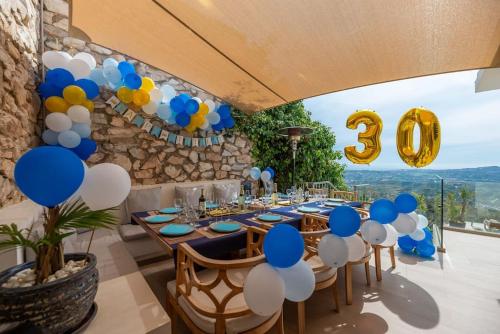 a table with blue and white balloons and a number sign at Villa Maya Bali Inspired Villa in Mijas