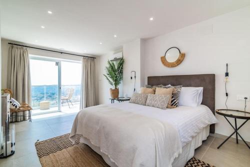 a bedroom with a large bed with a view of the ocean at Villa Maya Bali Inspired Villa in Mijas