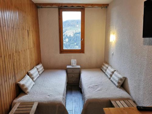 deux lits dans une chambre avec une fenêtre dans l'établissement Résidence Boulevard - BOULEVARD B04 MAE-3991, à Les Allues