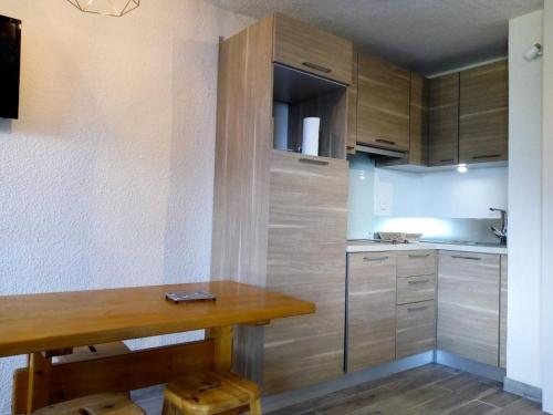 une cuisine avec des armoires en bois et une table en bois dans l'établissement Résidence Boulevard - BOULEVARD B04 MAE-3991, à Les Allues