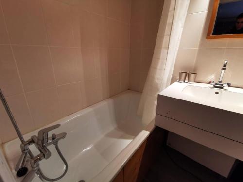 une salle de bain avec une baignoire blanche et un lavabo dans l'établissement Résidence Boulevard - BOULEVARD B04 MAE-3991, à Les Allues