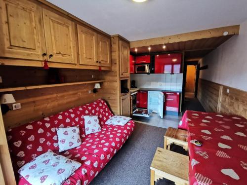 un salon avec un canapé rouge et une cuisine dans l'établissement Résidence Proveres - PROVERES 41 MAE-4001, à Les Allues