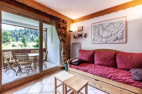 un salon avec un canapé rouge et un balcon dans l'établissement Résidence Alpages A - ALPAGES A4 MAE-4021, à Les Allues