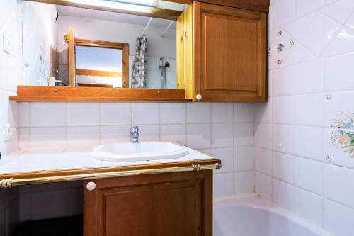 une salle de bain avec un lavabo, une baignoire et un miroir dans l'établissement Résidence Alpages A - ALPAGES A4 MAE-4021, à Les Allues