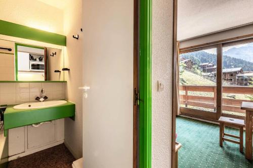 La salle de bains est pourvue d'un lavabo vert et d'une fenêtre. dans l'établissement Résidence Pralin - PRALIN 512 MAE-4041, à Les Allues