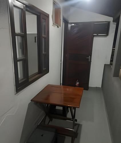 a small room with a wooden table and a window at otimo apart 2 quartos no recreio dos bandeirantes in Rio de Janeiro