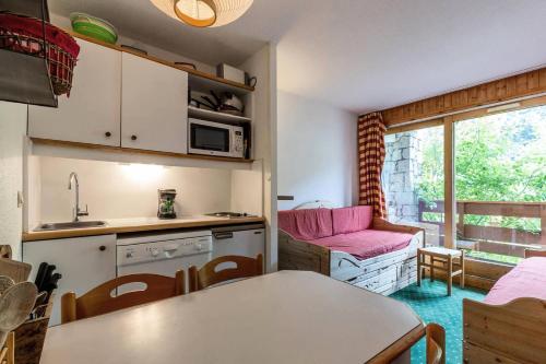 une cuisine et un salon avec une table et un canapé dans l'établissement Résidence Pralin - PRALIN 716 MAE-4031, à Les Allues