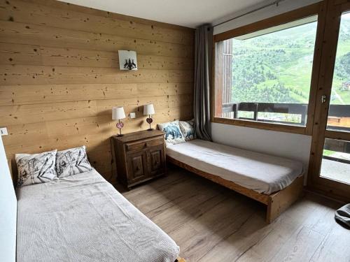 une chambre avec deux lits et une fenêtre dans l'établissement Résidence Arc En Ciel - ARC EN CIEL L10<br /> MAE-4071, à Les Allues