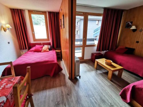 une chambre d'hôtel avec deux lits et une table dans l'établissement Résidence Candide - CANDIDE C12 MAE-4061, à Les Allues