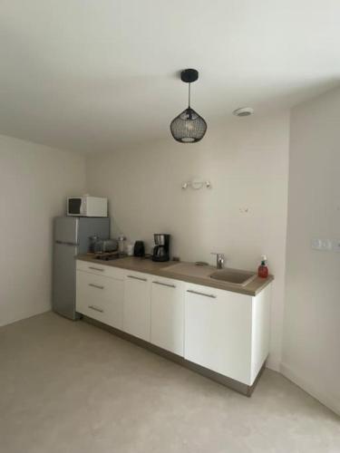 une cuisine avec un évier et un réfrigérateur dans l'établissement La Maison de Marie, à La Boissière-sur-Evre