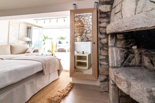 a bedroom with a stone fireplace and a mirror at Villa Maya Bali Inspired Villa in Mijas
