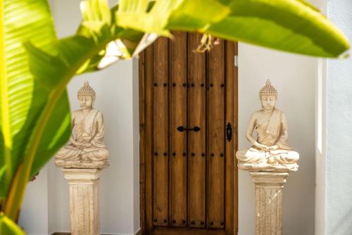 two statues sitting on pillars in front of a door at Villa Maya Bali Inspired Villa in Mijas