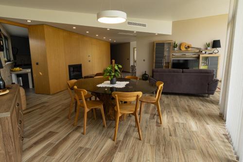 a dining room and living room with a table and chairs at Refúgio de luxo com spa, piscina interior e exterior - Pedra Aguda Spa in Fagilde