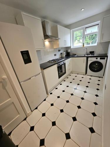 a kitchen with a black and white tiled floor at Wembley, Cosy 2 Bed Apa, Next to the park in Harrow on the Hill