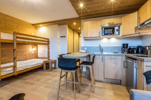- une cuisine avec une table et des lits superposés dans l'établissement Résidence Ruitor - RUITOR 113 MAE-4231, à Les Allues