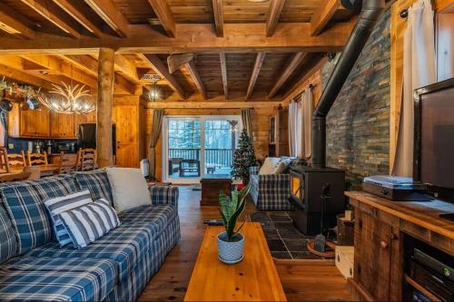 a living room with a couch and a fireplace at Rustic nature retreat with Hot Tub in Saint Adolphe D'Howard