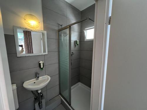 a bathroom with a sink and a shower at Interlaken Marco Hostel in Interlaken