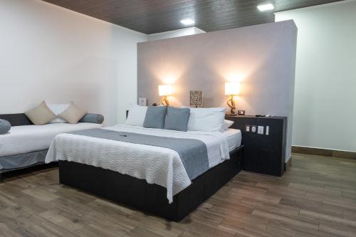 a bedroom with two beds and a couch in it at Hotel Boutique Casa Del Rio in Fortuna